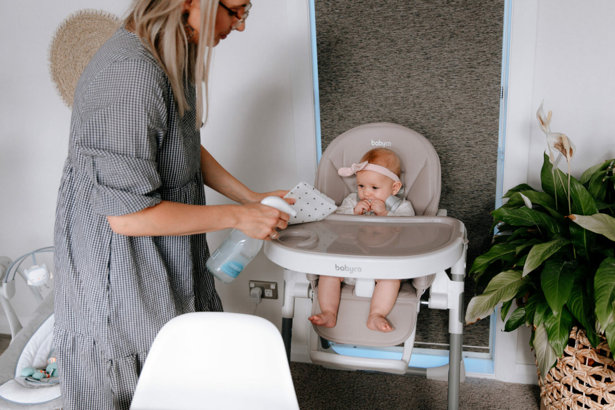 Mother cleaning babies highchair